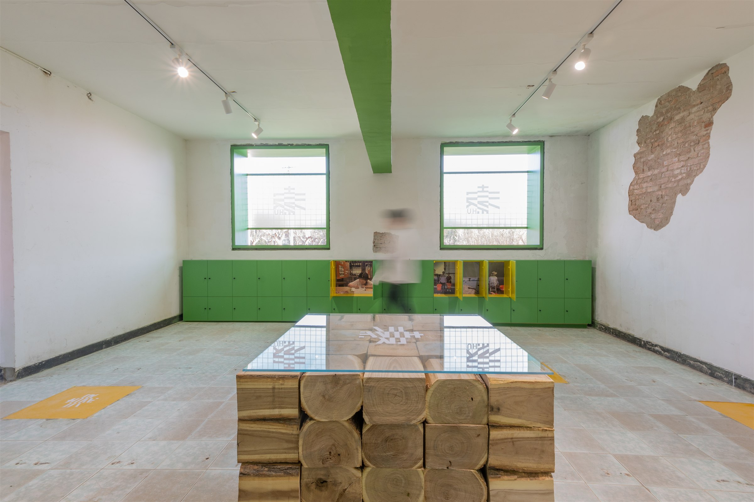South Gallery interior with green display cabinets and a timber-and-glass table